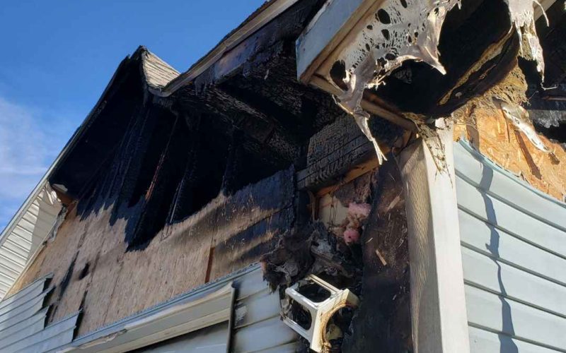 The exterior of a home exhibiting fire damage.